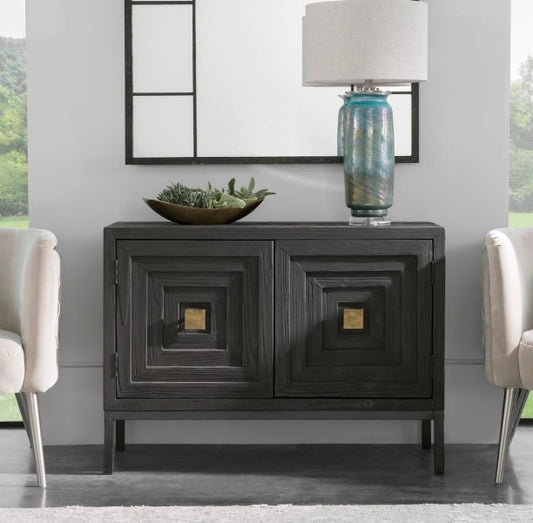 A modern black and gold 2 door cabinet with geometric design, featuring gold accents on the handles, in a room with a stylish interior.