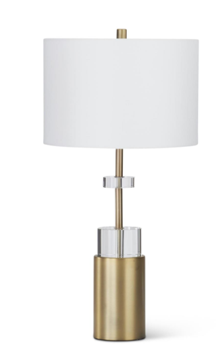 Table lamp with a white shade and gold base on a white background