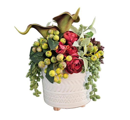 Decorative flower arrangement in a white textured vase on a wooden surface with a gray background
