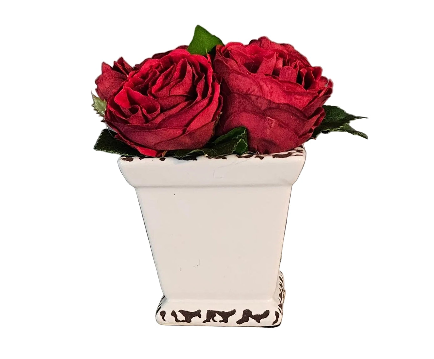 Two red roses in a white vase on a wooden surface with a gray wall background