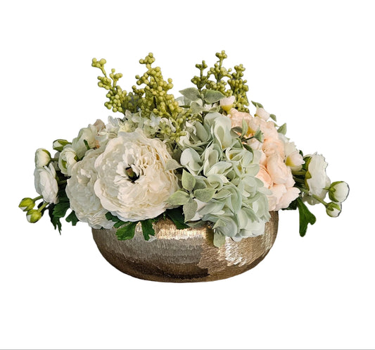 Floral arrangement in a metallic bowl on a white background