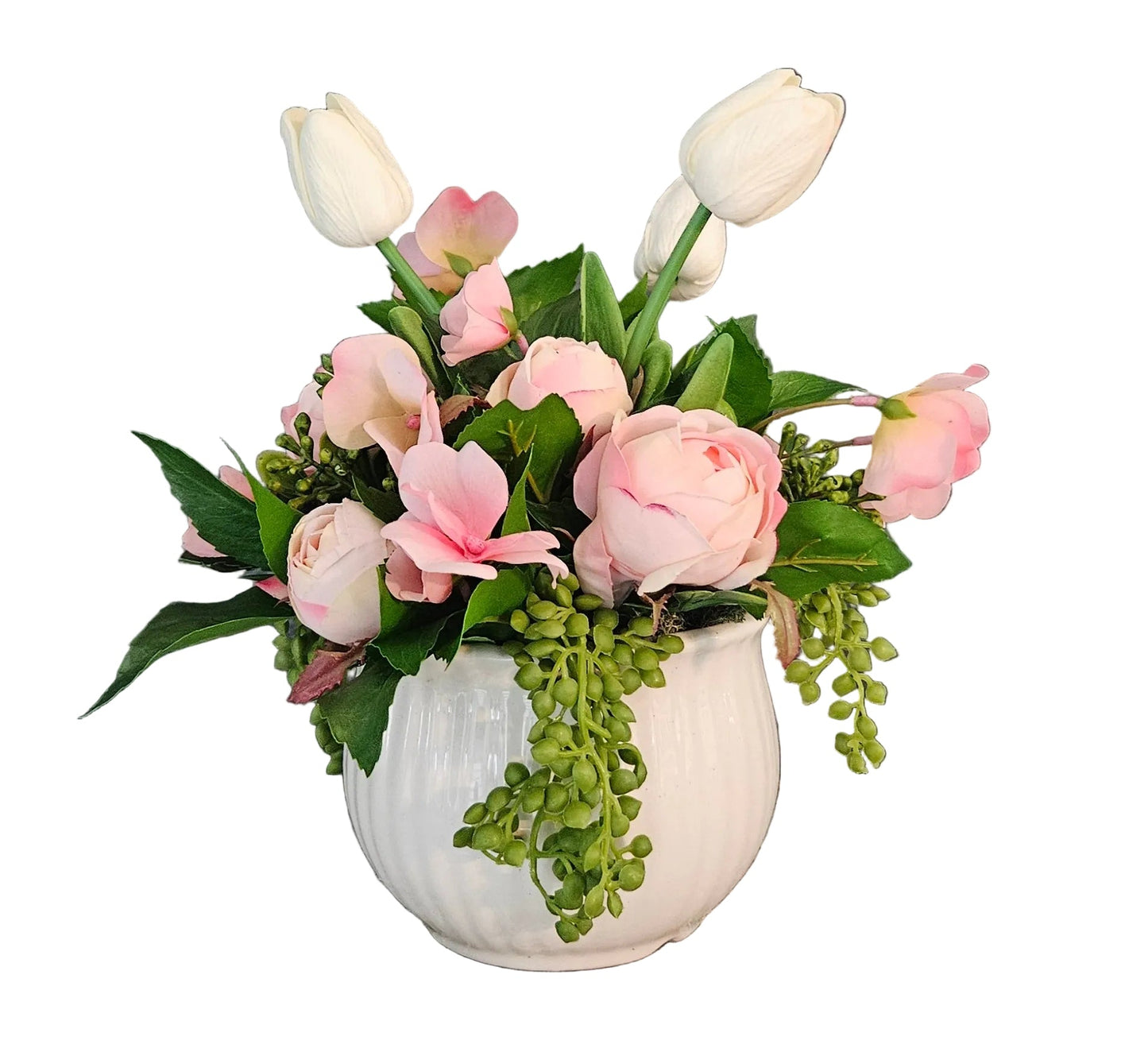 Floral arrangement with pink and white flowers in a white vase on a wooden surface.