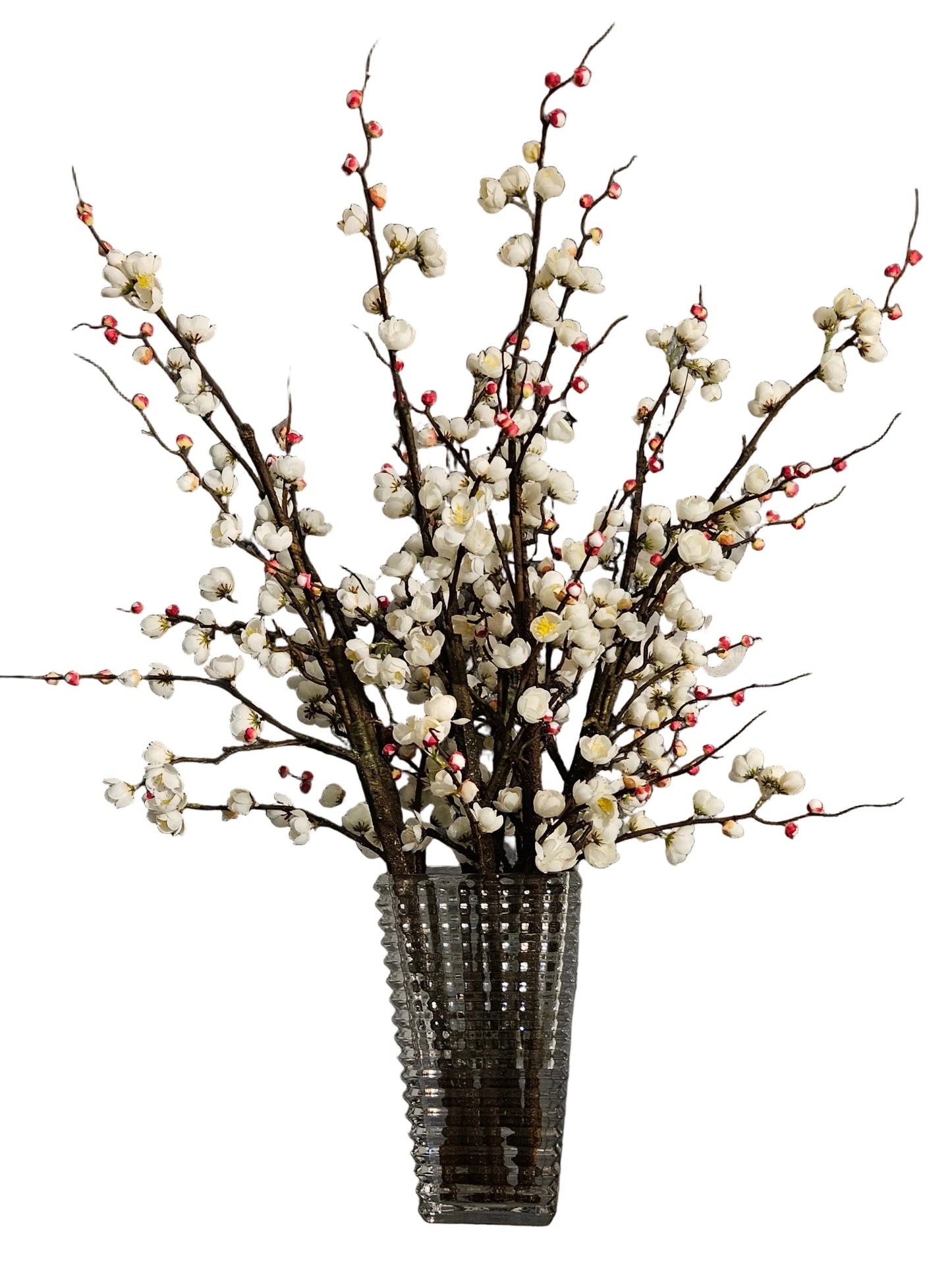 Artificial floral arrangement with white flowers and red berries in a clear glass vase on a white background