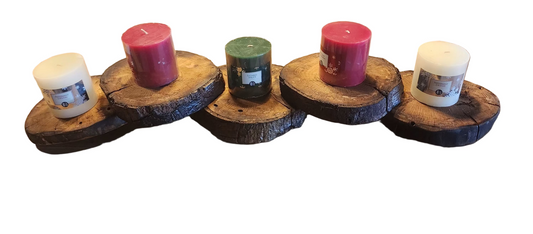 Five candles on wooden stumps on a wooden surface
