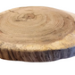 Wooden round cutting board with tree rings on a wooden surface