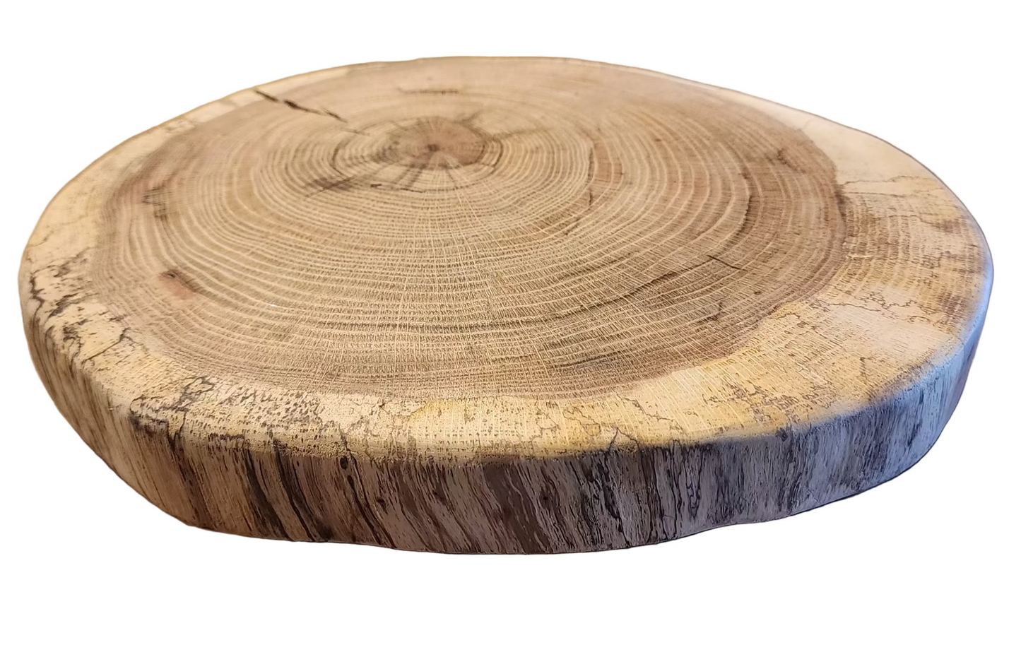 Wooden round cutting board with tree rings on a wooden surface