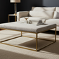 Modern living room with a beige sofa, leopard print ottoman, and decorative items.