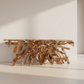 Teak root console table in a minimalistic room with large windows.
