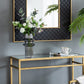 Modern interior with a gold console table, mirror, and chair against a gray wall.