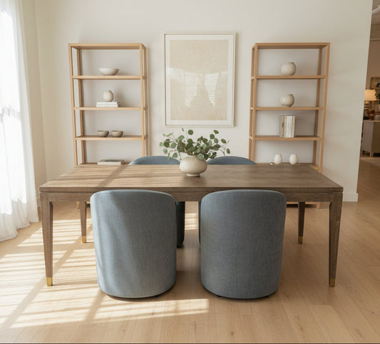 Dining room setup with a wooden table, blue stools, and decorative items in a showroom.