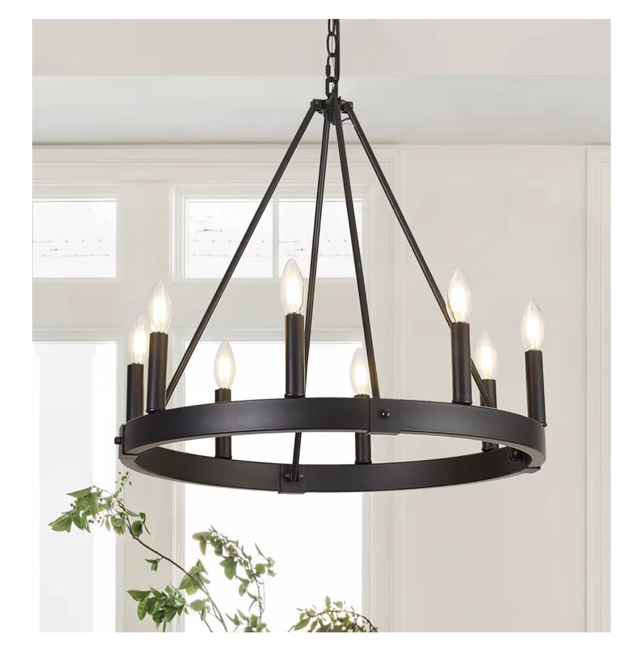 Black chandelier hanging in a room with white walls and a window.