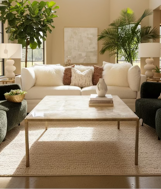 Coffee table with a agate surface in front of a beige sofa with decorative pillows.