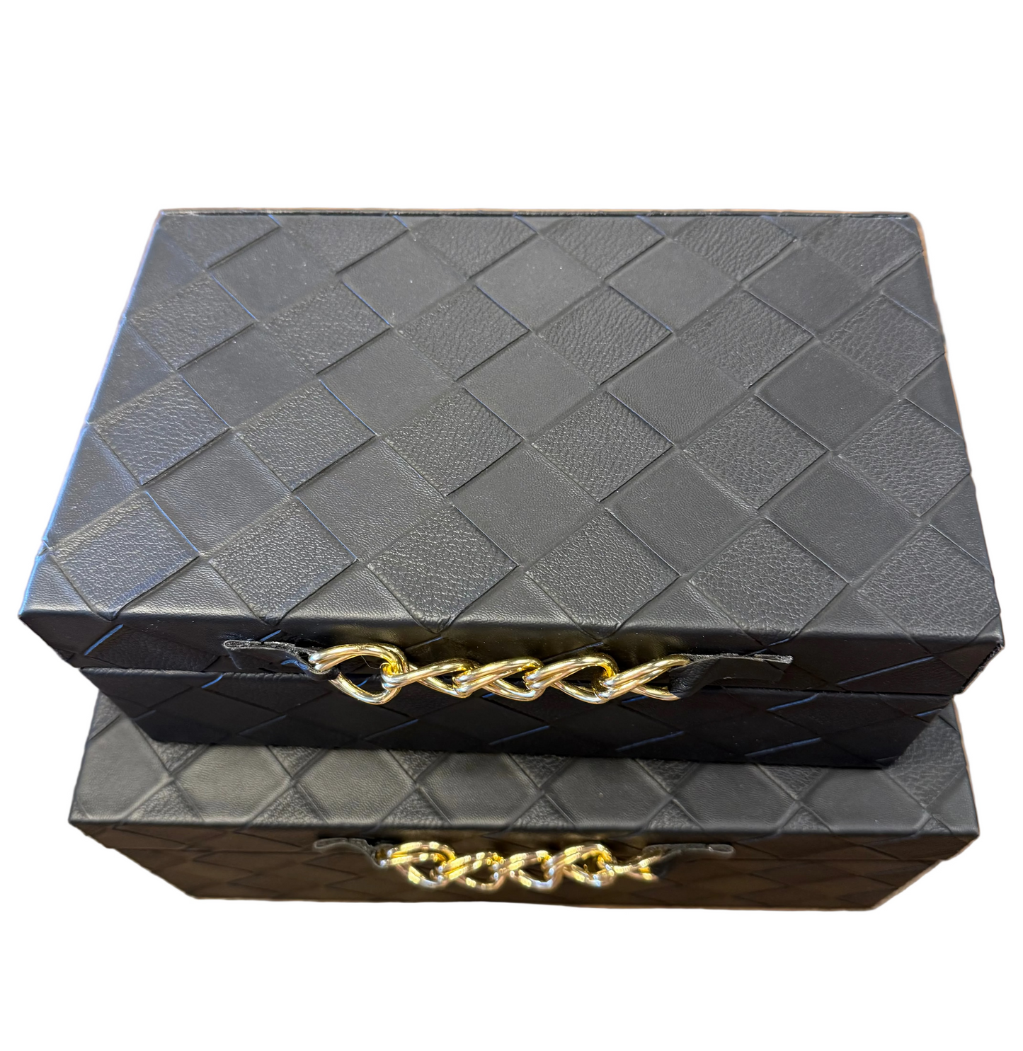 Two stacked black woven leather jewelry boxes with gold-tone chain handles, placed on a wooden tabletop.
