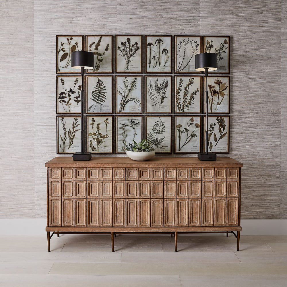 Wooden sideboard with framed botanical prints on a wall.