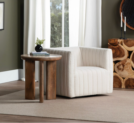 Modern living room with a white armchair, wooden side table, and decorative wall art.