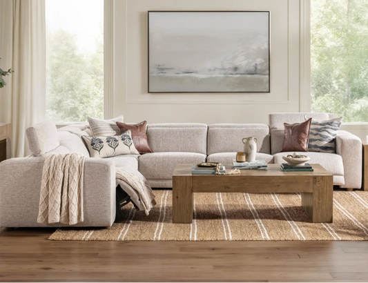 Modern living room with a sectional sofa, coffee table, and decorative elements.