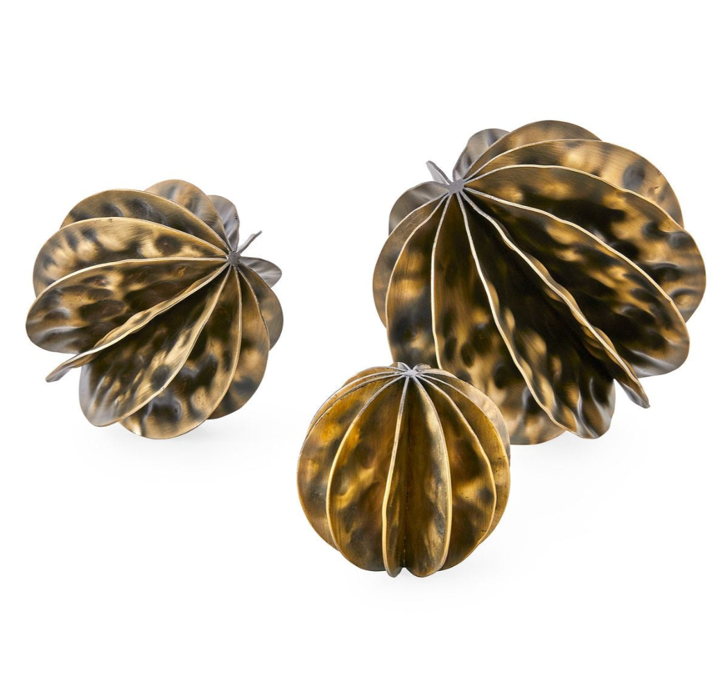 Three metallic decorative items with a star-like design on a white background