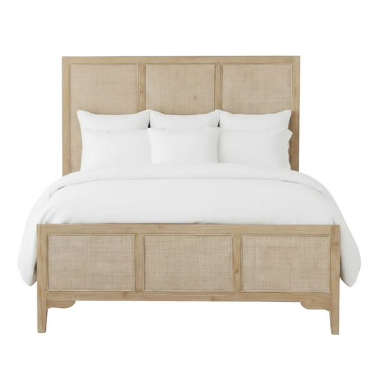 Wooden bed with wicker accents and white bedding on a white background
