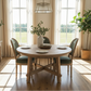 Dining room with a wooden table and chairs, plants, and large windows.