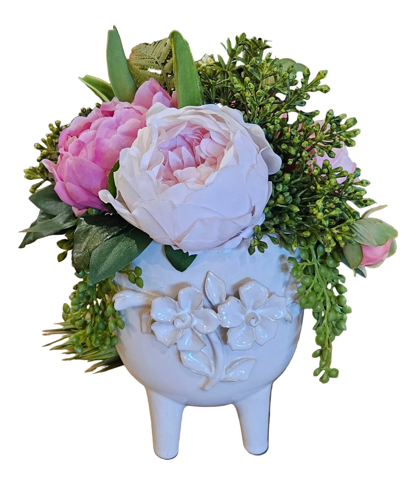 Floral arrangement in a decorative white vase on a wooden surface