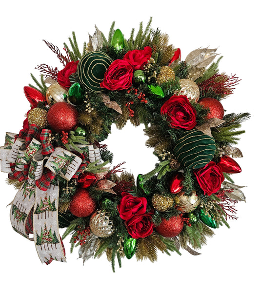 Decorative Christmas wreath with red flowers, gold and green ornaments on a white door.