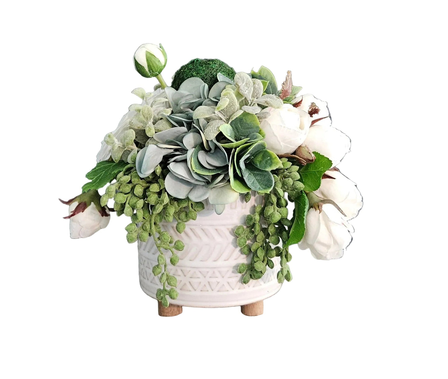 Floral arrangement in a white pot on a wooden surface with a gray wall background