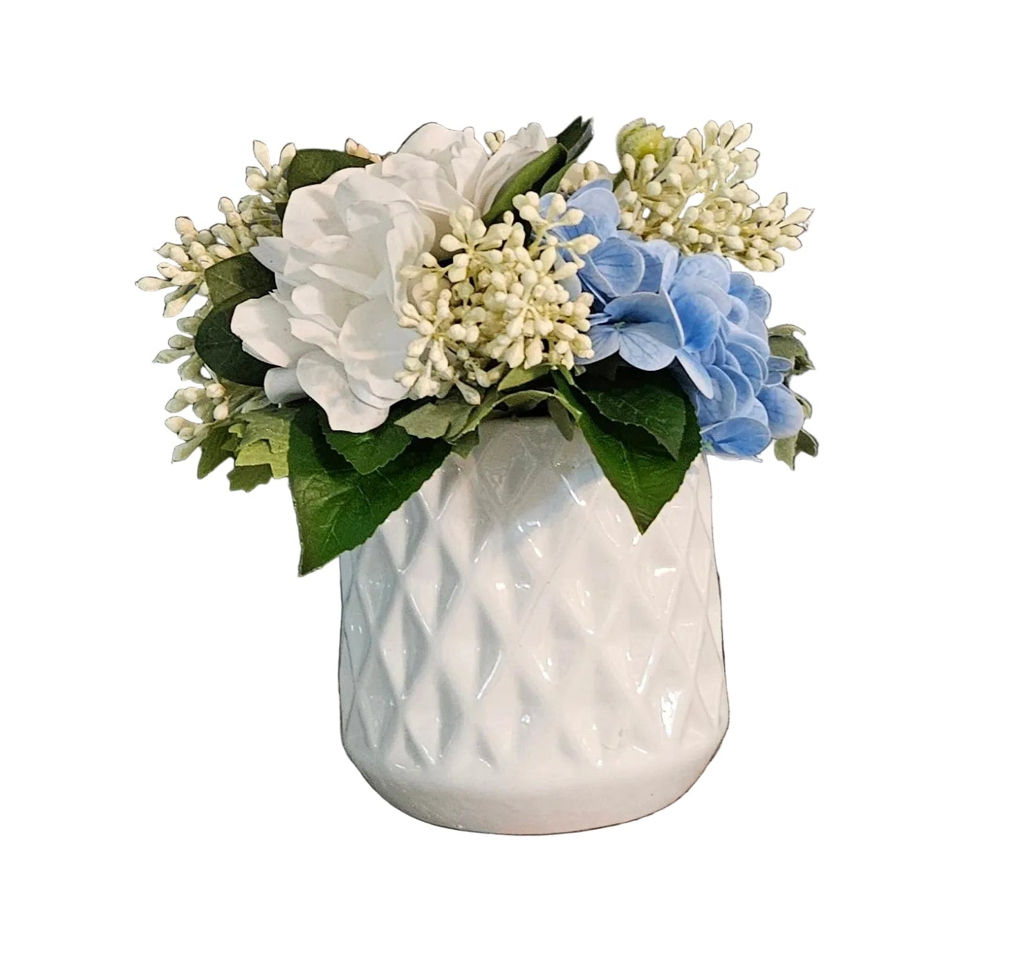 White textured vase with artificial flowers on a wooden surface against a gray wall