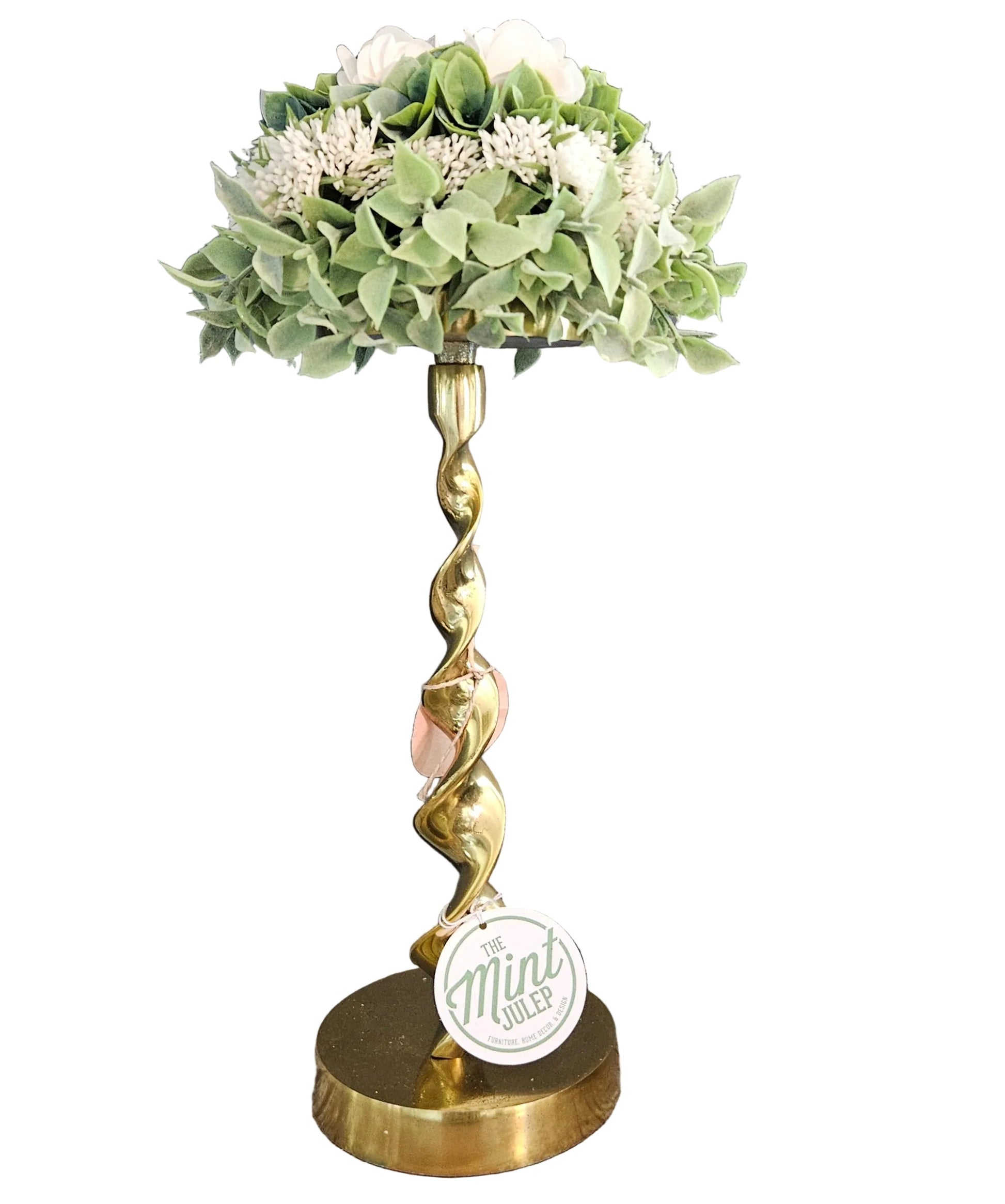 Decorative lamp with green floral arrangement on a white background