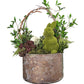 Decorative arrangement with a moss-covered bunny in a metal container against a white wall.