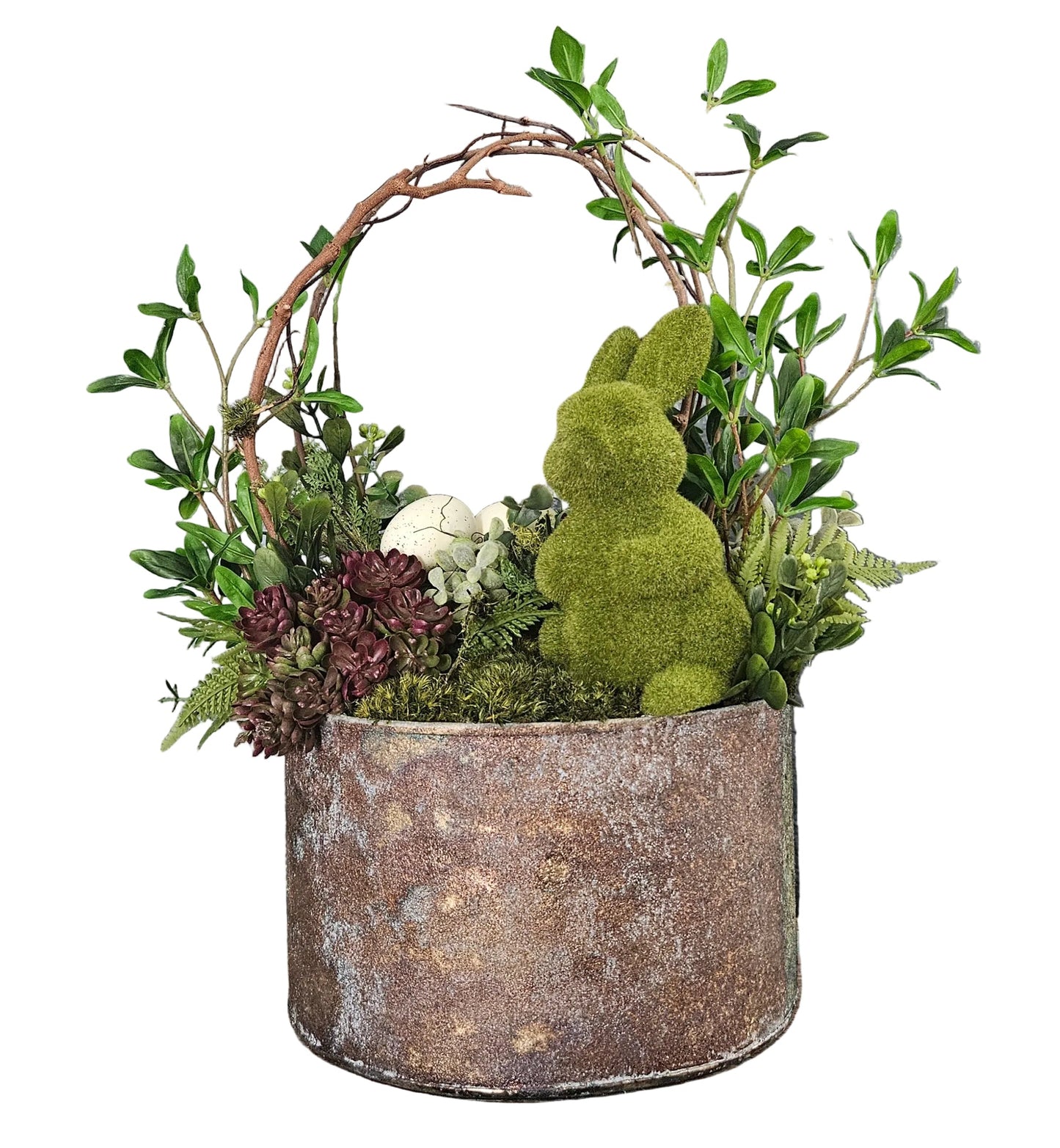 Decorative arrangement with a moss-covered bunny in a metal container against a white wall.