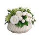Floral arrangement in a textured vase on a wooden surface with a gray wall background