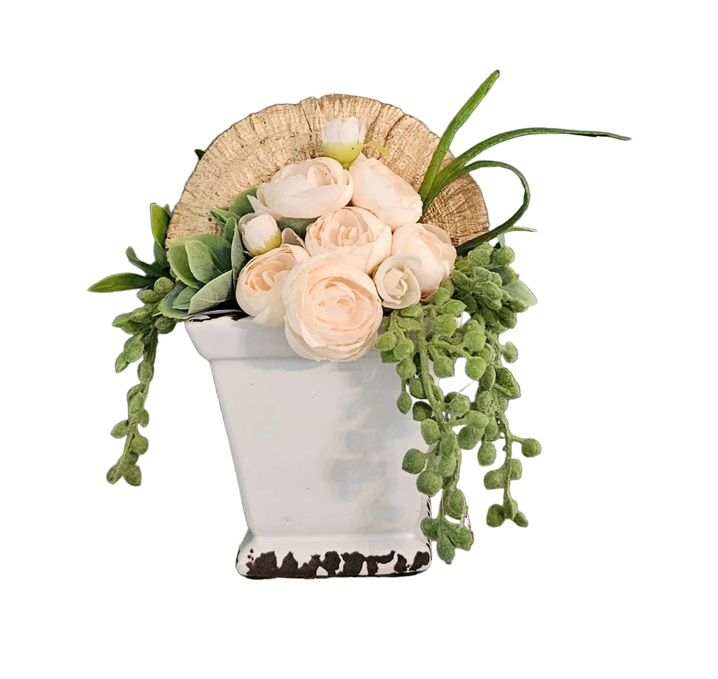 Floral arrangement in a white vase on a rustic wooden surface on a white wall