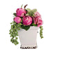 Pink flowers in a white container on a rustic wooden surface with a dark gray background