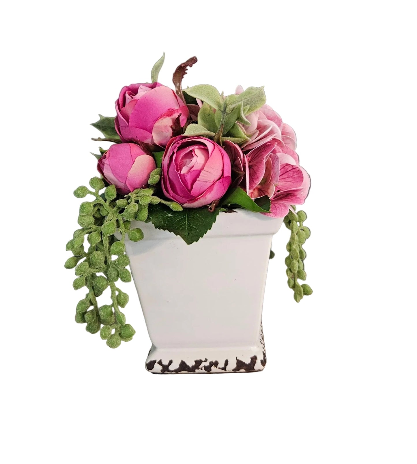 Pink flowers in a white container on a rustic wooden surface with a dark gray background