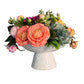 Floral arrangement in a white vase on a wooden surface with a gray wall background