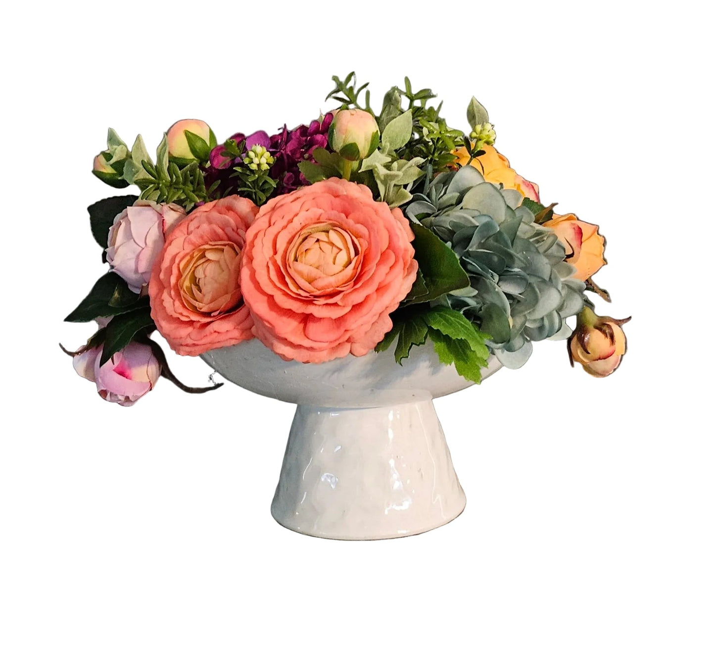 Floral arrangement in a white vase on a wooden surface with a gray wall background