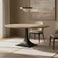 Dining room with a wooden table, chairs, and abstract art on the wall.